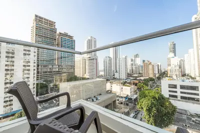 a balcony with two chairs and a view of a city at Luxury Duplex with Pool, Sunset Views, & Comfort in Cartagena de Indias