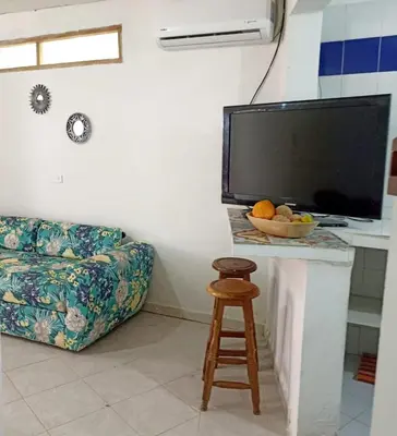 a living room with a couch and a table with a bowl of fruit at Hostal CORALES in Tolú