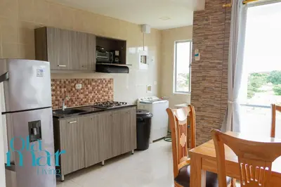 a kitchen with a stainless steel refrigerator and a table at Atardeceres bloque A in Coveñas