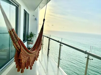 a hammock on a balcony overlooking the ocean at by Calamari Homes - Altamar 30B1 near walled city in Cartagena de Indias