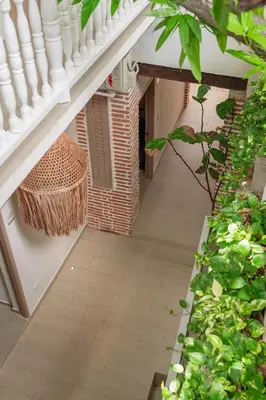 an internal courtyard of a house with a staircase and plants at Casa Helena Hostel in Cartagena de Indias