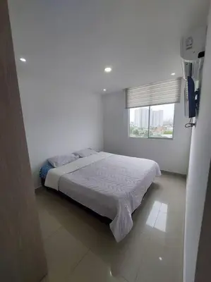 a bed in a white room with a window at Apartamento Cartagena - Terrazas de Calicanto in Cartagena de Indias