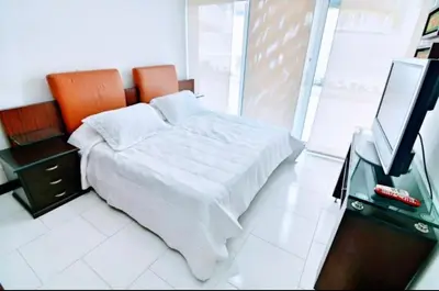 a bedroom with a bed and a flat screen tv at Apartamento con vista frontal al mar. in Cartagena de Indias