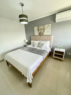 a bedroom with a large bed with a portrait on the wall at Cabrero Beach 906 in Cartagena de Indias