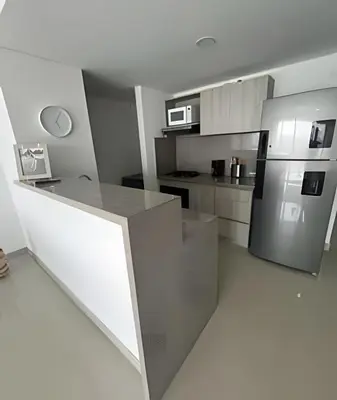 a kitchen with a counter and a stainless steel refrigerator at Apartamento 2 Dormitorios Vista Mar. Piscina in Cartagena de Indias