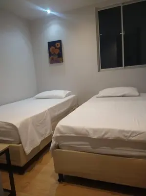 two twin beds in a room with a window at Confortable apto en Coveñas in Coveñas