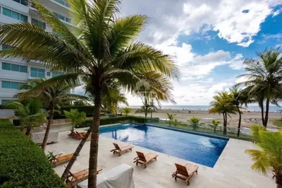 a swimming pool with palm trees and a beach at Morros Vitri Beachfront & 2 Bedrooms in Cartagena de Indias