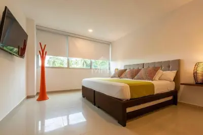 a bedroom with a large bed and a television at Morros Vitri Beachfront & 2 Bedrooms in Cartagena de Indias