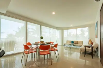 a dining room with a table and chairs and a couch at Morros Vitri Beachfront & 2 Bedrooms in Cartagena de Indias