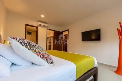 a bedroom with a bed with a tv on the wall at Morros Vitri Beachfront & 2 Bedrooms in Cartagena de Indias