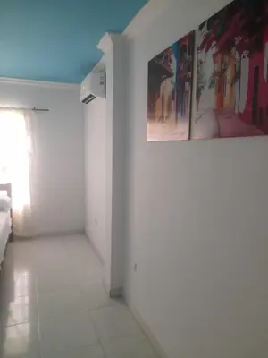 a white room with a painting on the wall at Hostal Renacer in Cartagena de Indias