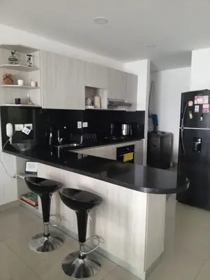 a kitchen with a black counter and two bar stools at Infinitum de lujo in Cartagena de Indias