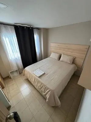 a bedroom with a large bed with a wooden headboard at Apartamento frente a la playa in Cartagena de Indias