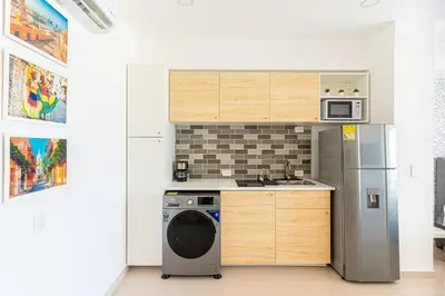 a kitchen with a washer and a refrigerator at Lujoso Apartamento Cartagena - 2 mins aeropuerto in Cartagena de Indias