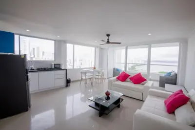 a living room with white furniture and pink pillows at Exclusivo Apartamento con vista al mar in Cartagena de Indias