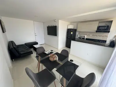 a kitchen and a living room with a table and chairs at Apartamento en Coveñas in Coveñas
