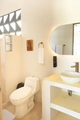 a white bathroom with a toilet and a sink at Cabaña privada & Villas Iluka in Coveñitas