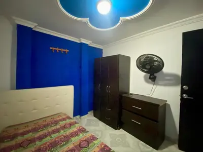 a bedroom with a bed and a blue wall at Casa Tranquila in Cartagena de Indias