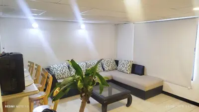 a living room with a couch and a plant at Hermosa casa cerca de la playa in Cartagena de Indias