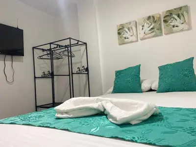 a bedroom with two beds with green pillows at Shekinah House in Cartagena de Indias