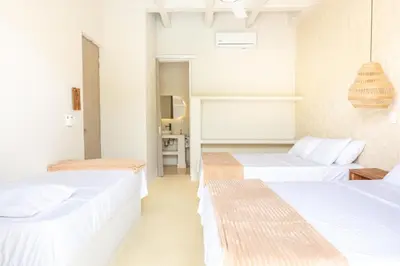 two beds in a room with white walls at Villa con piscina privada en coveñas sucre in Coveñas