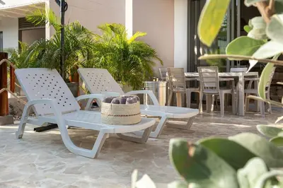 a patio with chairs and a table with a hat on it at Villa privada en coveñas sucre in Coveñas