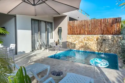 a swimming pool with chairs and an umbrella at Villa privada en coveñas sucre in Coveñas