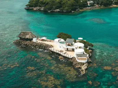 an island with a house in the water at Isla Pelícano in Isla Grande