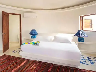 a bedroom with a large white bed with two lamps at Isla Pelícano in Isla Grande