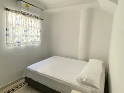 a small bedroom with a bed and a window at Muy cerca del mar, areopuerto y centro histórico in Cartagena de Indias