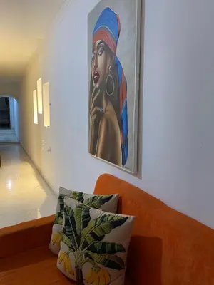 a painting of a woman on the wall next to a couch at Cómodo apartamento para hospedaje in Cartagena de Indias