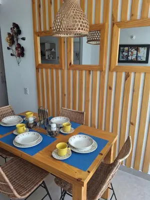 a wooden table with plates and cups on it at Apartamento Cartagena cerca a la playa in Cartagena de Indias