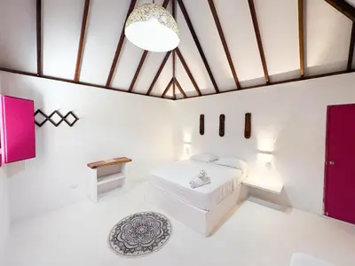 a bedroom with white walls and a large ceiling at Hotel Coral Sand Islas Del Rosario in Isla Grande