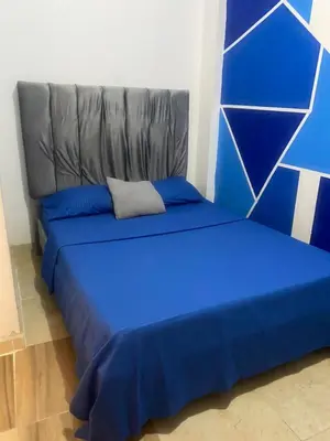a blue bed in a room with a couch at Hotel Corales del Mar in Cartagena de Indias