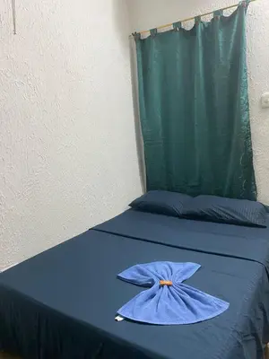 a bed with a blue sheets and a blue pillow at Hotel Corales del Mar in Cartagena de Indias