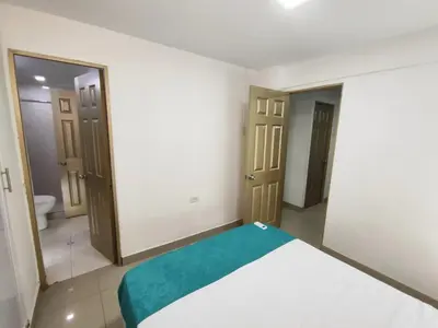 a bedroom with a bed with a green blanket at EM2-1G APARTAMENTO DE 2 HAB CERCA AL MAR ZONA RESIDENCIA WIFi Y PARQUEADERO in Cartagena de Indias