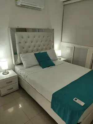 a bedroom with a large bed with a remote control on it at EM2-1G APARTAMENTO DE 2 HAB CERCA AL MAR ZONA RESIDENCIA WIFi Y PARQUEADERO in Cartagena de Indias