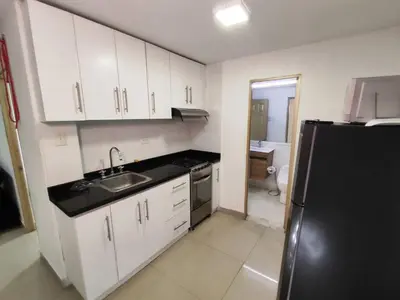 a kitchen with white cabinets and a black refrigerator at EM2-1G APARTAMENTO DE 2 HAB CERCA AL MAR ZONA RESIDENCIA WIFi Y PARQUEADERO in Cartagena de Indias