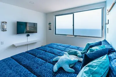 a bedroom with a blue bed and a window at Cartagena Paradise Beach Home Sleeps 7 in Cartagena de Indias