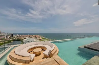a swimming pool on top of a building with the ocean at Stunning Sea View and Historic Center 20th FL/ 2BR in Cartagena de Indias
