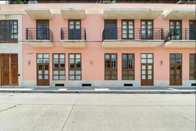 an empty street in front of a pink building at Cozy New Apartment in the Old City in Cartagena de Indias