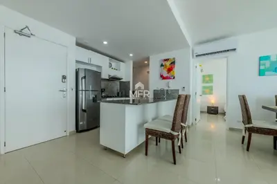 a kitchen with a bar with chairs and a kitchen island at Morros Epic - La Boquilla, Seaview & 2Bdr in Cartagena de Indias