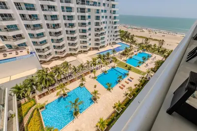 a view of the pool and beach from the balcony of a resort at Morros Epic - La Boquilla, Seaview & 2Bdr in Cartagena de Indias
