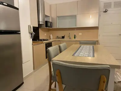 a kitchen with a table and some chairs in it at HERMOSOS APARTAMENTOS EN La CIUDAD VIEJA in Cartagena de Indias