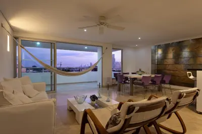 a living room with a white couch and a dining room at APARTAMENTO GRANDE CARTAGENA La Matuna in Cartagena de Indias