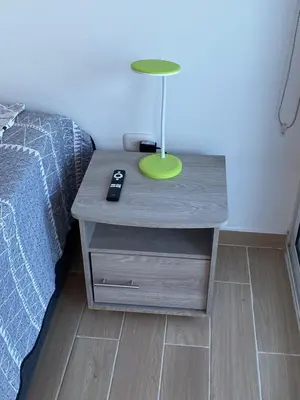 a nightstand with a lamp on it next to a bed at Apartamento LOFT INFINITY BLUE in Santa Marta