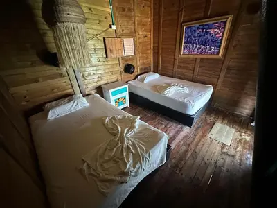 a bedroom with two beds in a wooden room at Casa en el agua in Tintipan Island