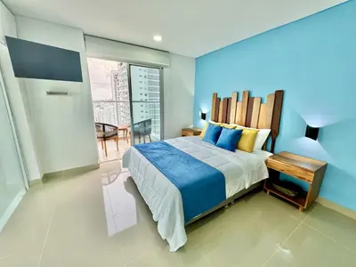 a bedroom with a large bed with blue walls at apto navy 6 tripulantes in Cartagena de Indias