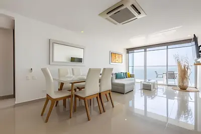 a white dining room with a table and chairs at Sea View and Historic Center “Morros City” 2BR in Cartagena de Indias