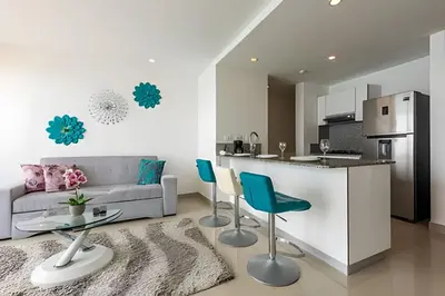 a kitchen and living room with a couch and a table at Vista al Mar y Centro Histórico “Morros City” 26fl in Cartagena de Indias